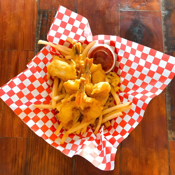 Alfie's Fish & Chips: golden-fried shrimp and french fries in a red and white checkered basket.